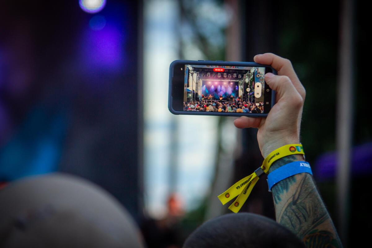 A fan snaps photos of Jimmy Eat World at Outlandia Festival on Aug. 12, 2023. 